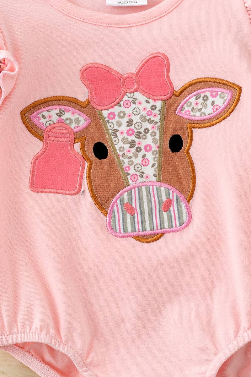 Pink cow applique baby bodysuit with floral ruffle on sleeves and ruffle butt.