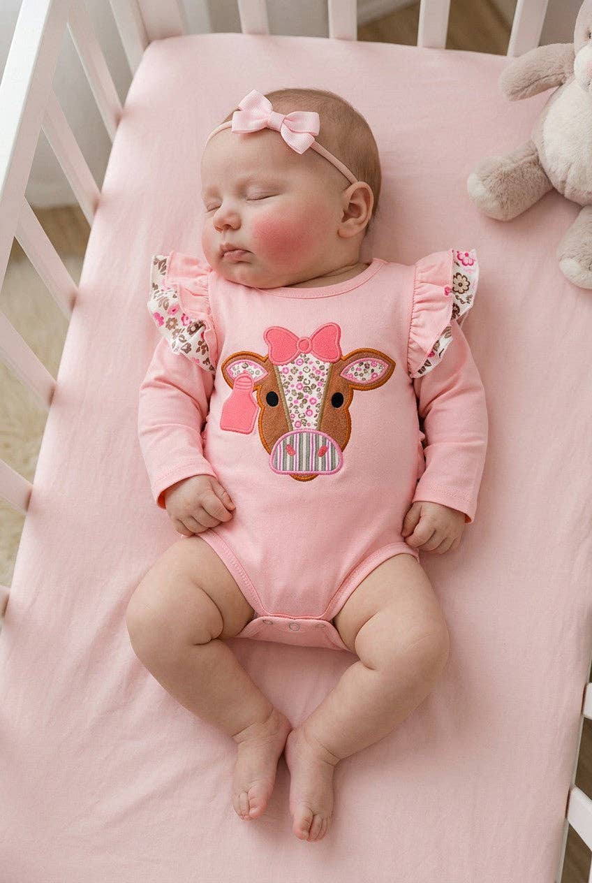 Pink cow applique baby bodysuit with floral ruffle on sleeves and ruffle butt.