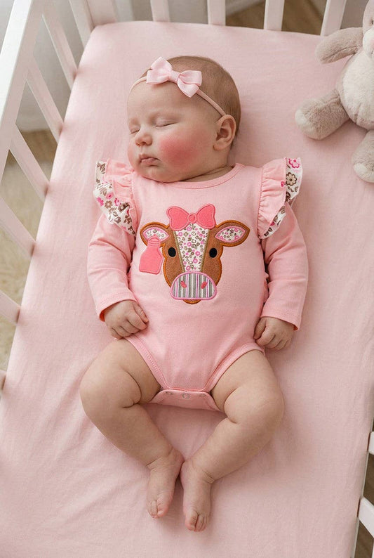 Pink cow applique baby bodysuit with floral ruffle on sleeves and ruffle butt.